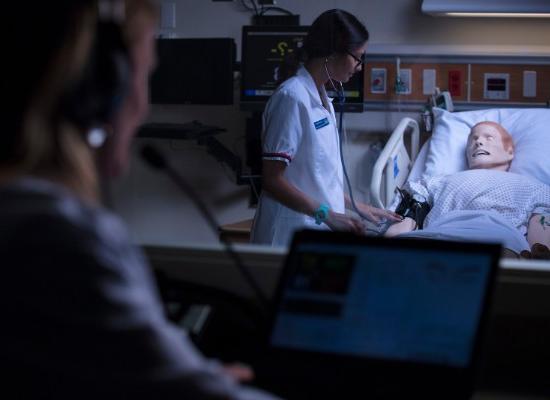 在线博彩 Nursing student treating test patient. 